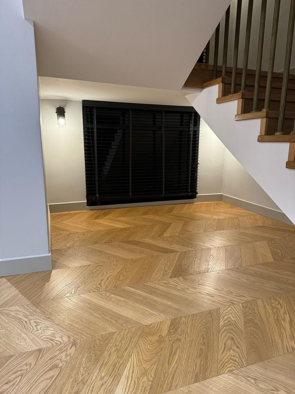 Natural oak chevron parquet fitted in a hallway under a staircase